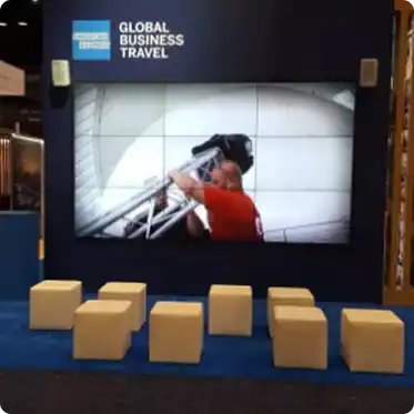 LED video wall setup at trade show booth with branded content and audience seating